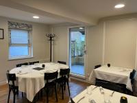 un comedor con mesas y sillas blancas y una ventana en Restaurant Hotel Logis Chez Sophie, en Briouze