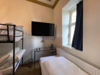 Zimmer mit 2 Etagenbetten und einem Flachbild-TV in der Unterkunft Amsterdam Rembrandt Square city center Hotel in Amsterdam
