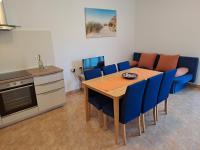 a kitchen with a dining room table and blue chairs at Apartment Greta in Kanfanar