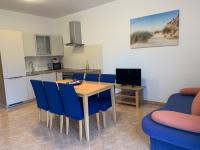 a kitchen and dining room with a table and blue chairs at Apartment Greta in Kanfanar