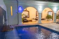 a swimming pool in a house with a fountain at Pousada Boulevard in Cabo Frio