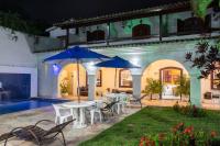 a patio with a table and chairs and blue umbrellas at Pousada Boulevard in Cabo Frio