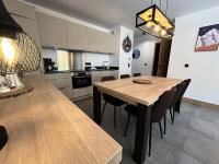 a kitchen and dining room with a wooden table and chairs at Résidence LES TERRASSES DE LA VANOISE - Appartement LES TERRASSES DE LA VAN 924 in Champagny-en-Vanoise