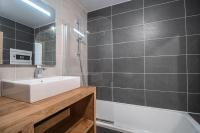 a bathroom with a white sink and a tub at Résidence LES TERRASSES DE LA VANOISE - Appartement LES TERRASSES DE LA VAN 924 in Champagny-en-Vanoise