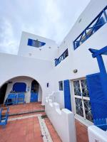 a white building with blue doors and stairs at Greek Frontier Villa in Magong