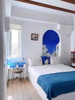 a white and blue bedroom with a bed and a window at Greek Frontier Villa in Magong