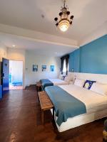 two beds in a bedroom with blue walls and a chandelier at Greek Frontier Villa in Magong