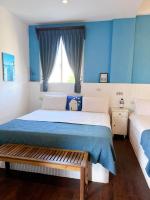 a bedroom with two beds with blue walls at Greek Frontier Villa in Magong