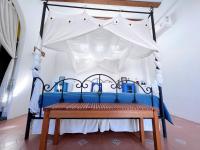 a blue and white canopy bed with a bench at Greek Frontier Villa in Magong