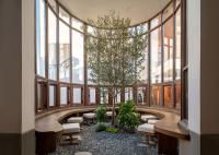 a hallway with benches and a tree in a building at SAVHE Hotel Shanghai World Expo in Shanghai
