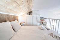 a bedroom with a white bed with a wooden ceiling at Résidence Les Horizons D&#39;huez - 2 Pièces pour 4 Personnes 724 in LʼHuez