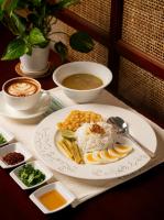 a table with a plate of food and a bowl of soup at Governor's Residence in Yangon