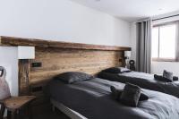 a bedroom with two beds and a wooden headboard at Résidence Le Bercail - Chalets pour 12 Personnes 224 in Saint-Martin-de-Belleville