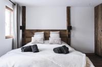 a large white bed with two black pillows on it at Résidence Le Bercail - Chalets pour 12 Personnes 224 in Saint-Martin-de-Belleville