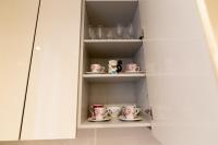 a cupboard with a bunch of cups and saucers at We Love Paris - Private Apartment in Vitry-sur-Seine