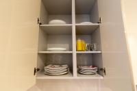 a white cupboard with plates and dishes in it at We Love Paris - Private Apartment in Vitry-sur-Seine