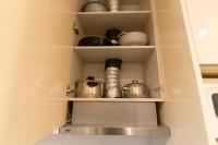 a kitchen shelf with pots and pans on it at We Love Paris - Private Apartment in Vitry-sur-Seine