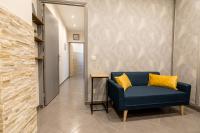 a blue chair with yellow pillows in a hallway at We Love Paris - Private Apartment in Vitry-sur-Seine