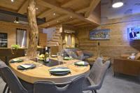 a dining room with a large wooden table and chairs at La cabane luxury apartment in the heart of the village in La Grave