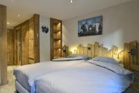 a bedroom with two beds with wooden walls at La cabane luxury apartment in the heart of the village in La Grave