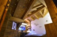 a room with wooden ceilings and a bed in a house at La cabane luxury apartment in the heart of the village in La Grave