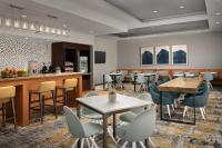a restaurant with tables and chairs and a bar at TownePlace Suites by Marriott Cheyenne Southwest/Downtown Area in Cheyenne