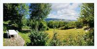 a white bench in a field with trees and bushes at Maison de 2 chambres avec jardin clos a Le Fau 