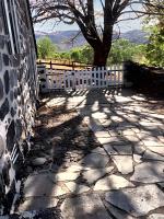 a stone walkway with a white fence and a tree at Maison de 2 chambres avec jardin clos a Le Fau 