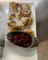 a plate of food with a spoon on a table at Hotel-Restaurant Gasthaus Bonimeier in Niedergottsau