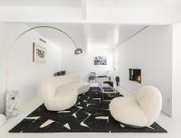 ein Wohnzimmer mit 2 weißen Stühlen und einem Teppich in der Unterkunft Former Steve McQueen’s home in Palm Springs