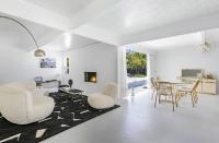 ein Wohnzimmer mit weißen Wänden sowie einem Tisch und Stühlen in der Unterkunft Former Steve McQueen’s home in Palm Springs