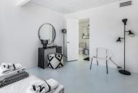ein Schlafzimmer mit einem Bett, einem Spiegel und einem Stuhl in der Unterkunft Former Steve McQueen’s home in Palm Springs