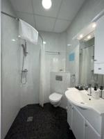 a white bathroom with a toilet and a sink at Hôtel Le National in Saint-Étienne