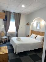 a bedroom with a large white bed and a window at Hôtel Le National in Saint-Étienne