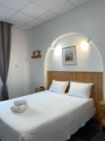 a bedroom with a large white bed with two towels on it at Hôtel Le National in Saint-Étienne