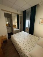 a hotel room with a bed and a bathroom at Hôtel Le National in Saint-Étienne