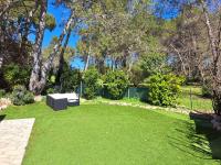un parque con un banco en el césped en Maisonnette au milieu des pins, en Mougins