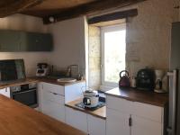 a kitchen with white cabinets and a window at Maison piscine Lot in Laburgade