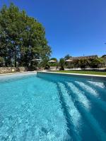 a large swimming pool with blue water at Maison piscine Lot in Laburgade