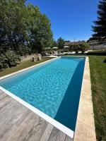 a blue swimming pool with a wooden deck at Maison piscine Lot in Laburgade