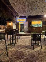 Un restaurante con sillas y mesas y un letrero de neón. en Les Hébergements Insolites Catalans, en Saint-André