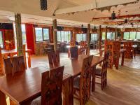 Un comedor con mesas y sillas de madera. en Orng'atuny Mara King Camp, en Masai Mara
