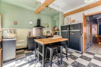 a kitchen with black appliances and a wooden table at Le Grappillon in Fitou
