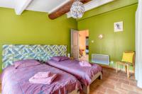 a bedroom with two beds and a green wall at Le Grappillon in Fitou