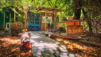 una pasarela frente a una casa con una puerta azul en El Jardin, Eco Cabañas Boutique, en San Alfonso