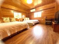 a bedroom with two beds in a wooden cabin at Annongriver B&amp;B in Sanxing