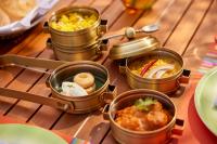 Storii By ITC Hotels Devasom Resort & Spa, Kolkata في Bāruipur: طاولة عليها أربع علب طعام