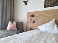 a bedroom with a bed and a chair with a pillow at Sweet Cherry - Boutique &amp; Guesthouse Tyrol in Innsbruck