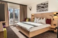 a bedroom with a large bed and a balcony at Sweet Cherry - Boutique &amp; Guesthouse Tyrol in Innsbruck