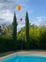 two hot air balloons flying over a swimming pool at Manoir Du Parc (Adults only) in Amboise